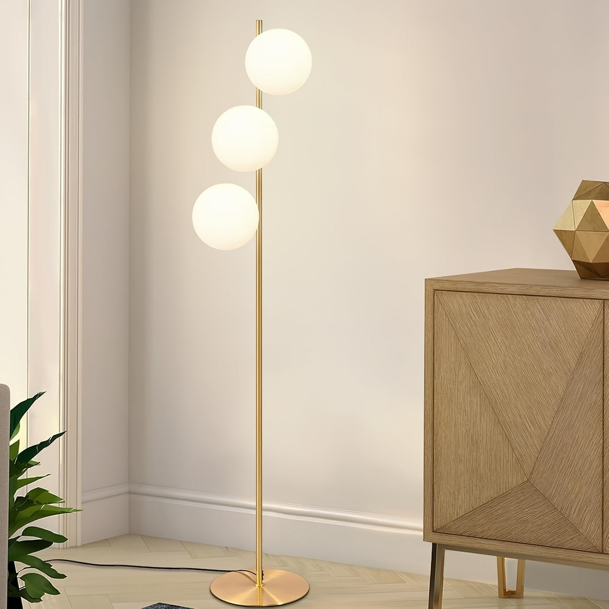 Lampadaire à trois globes opalins étagés sur tige dorée