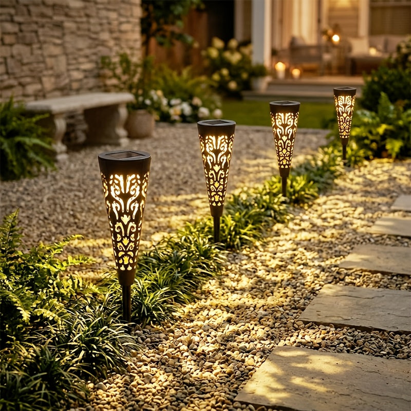 Lampe solaire torche ajourée noire, ombres florales sur l'allée