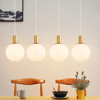 Suspension 4 globes en verre blanc strié sur barre dorée de 86 cm