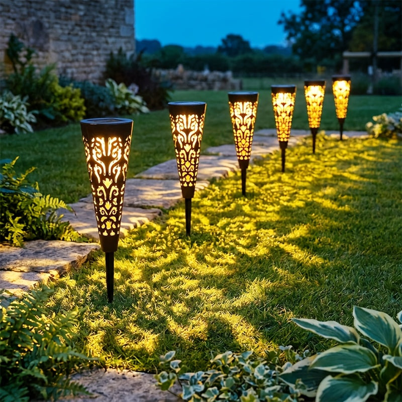 Lampe solaire torche ajourée noire, ombres florales sur l'allée