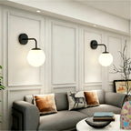 Applique murale globe opalin blanc sur bras courbé en métal noir