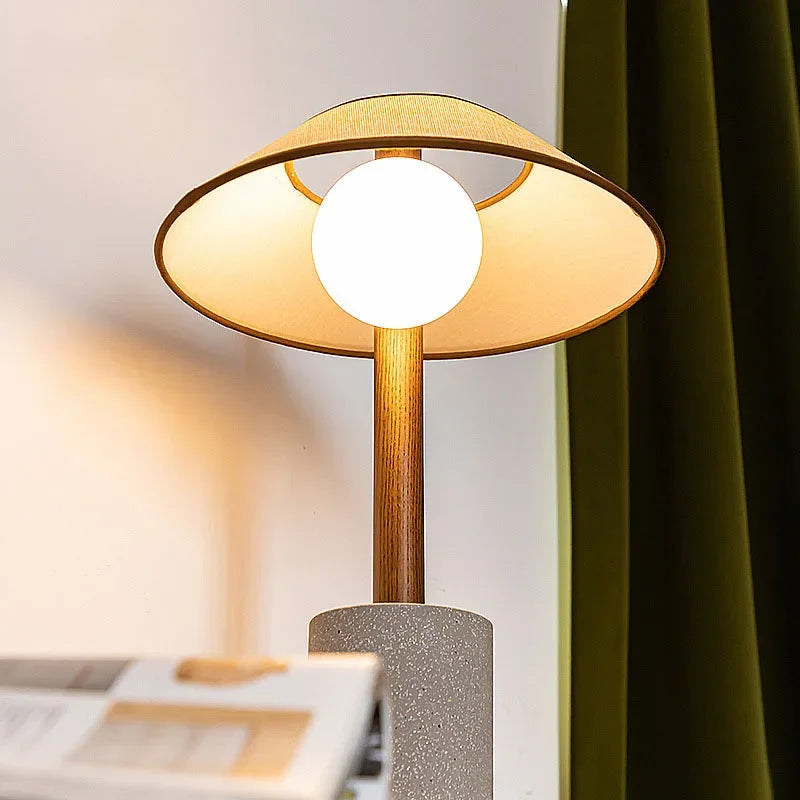 Lampe à poser en bois et ciment, chapeau en tissu et globe en verre