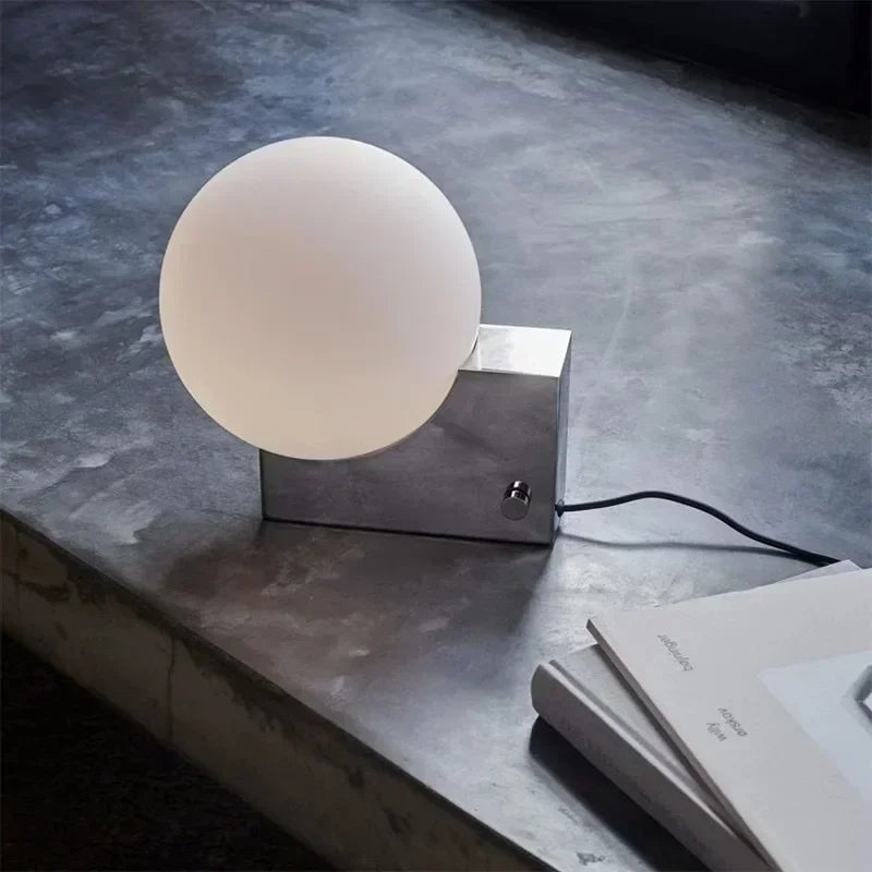Lampe à poser globe en verre sur bloc de métal, variateur rotatif