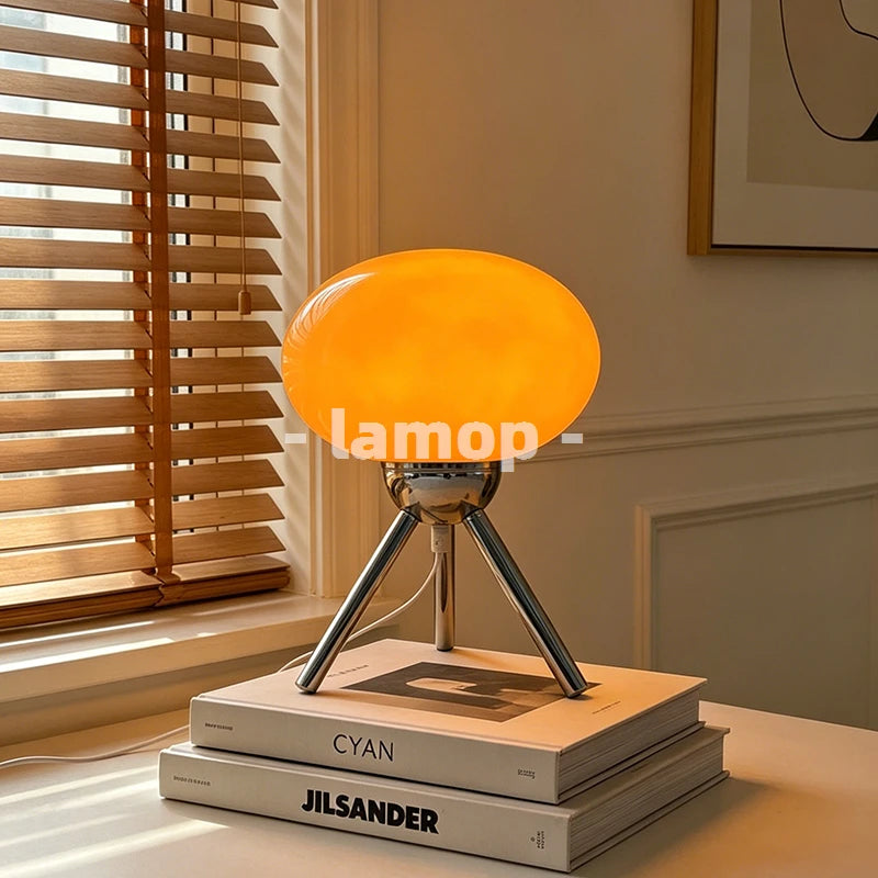 Un ovale de verre orange perché sur trépied