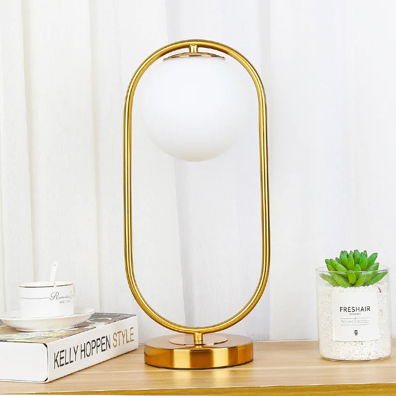 Lampe à poser globe en verre opalin dans un anneau doré ou noir