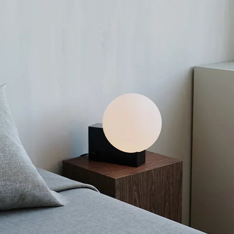 Lampe à poser globe en verre sur bloc de métal, variateur rotatif