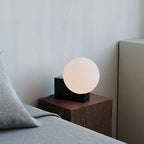 Lampe à poser globe en verre sur bloc de métal, variateur rotatif