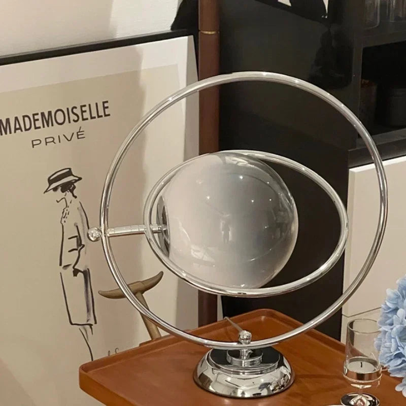 Lampe à poser globe de verre cerclé d'anneaux chromés, style Saturne