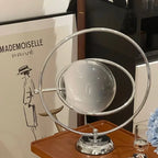Lampe à poser globe de verre cerclé d'anneaux chromés, style Saturne