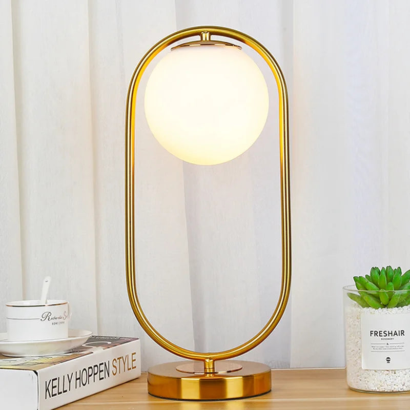 Lampe à poser globe en verre opalin dans un anneau doré ou noir