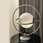 Lampe à poser globe de verre cerclé d'anneaux chromés, style Saturne