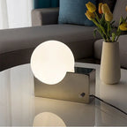 Lampe à poser globe en verre sur bloc de métal, variateur rotatif