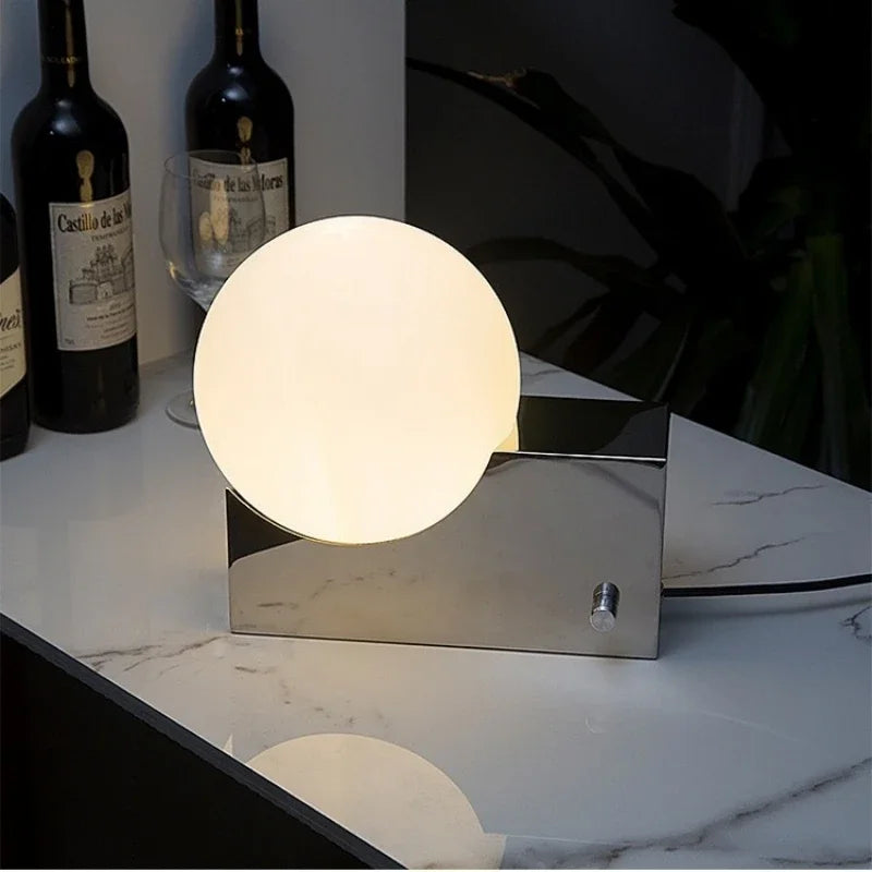 Lampe à poser globe en verre sur bloc de métal, variateur rotatif