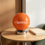 Lampe de table sphère en verre orange sur socle chromé court