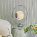 Lampe à poser globe de verre cerclé d'anneaux chromés, style Saturne