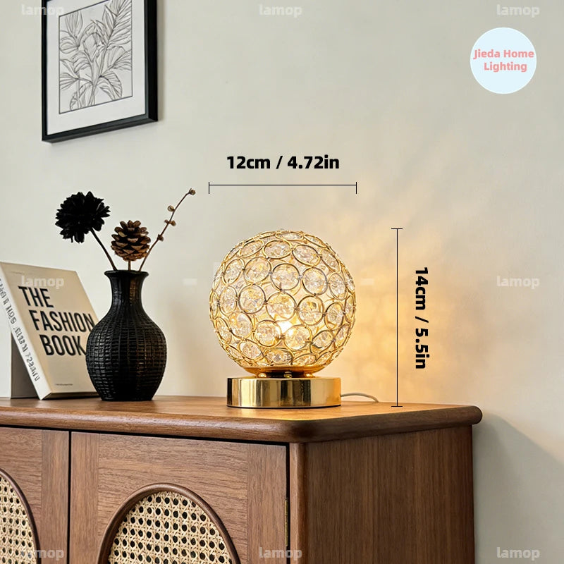Lampe à poser globe en métal ajouré et cristal, dorée ou argentée