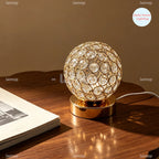 Lampe à poser globe en métal ajouré et cristal, dorée ou argentée