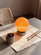 Lampe de table sphère en verre orange sur socle chromé court