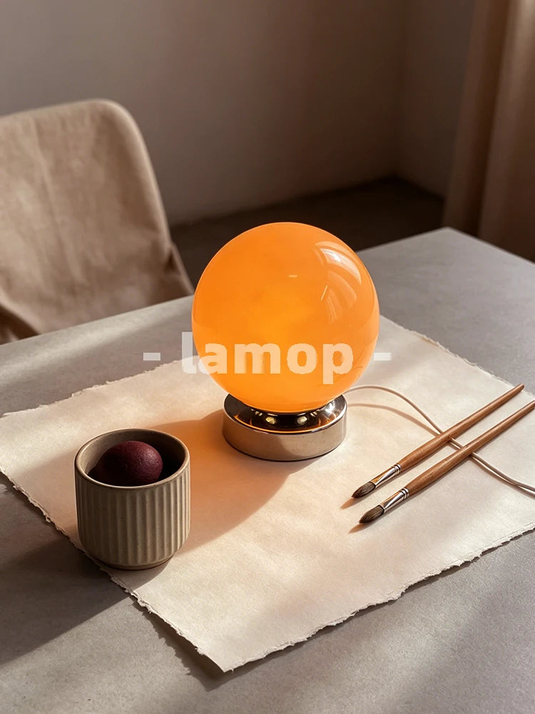 Lampe de table sphère en verre orange sur socle chromé court