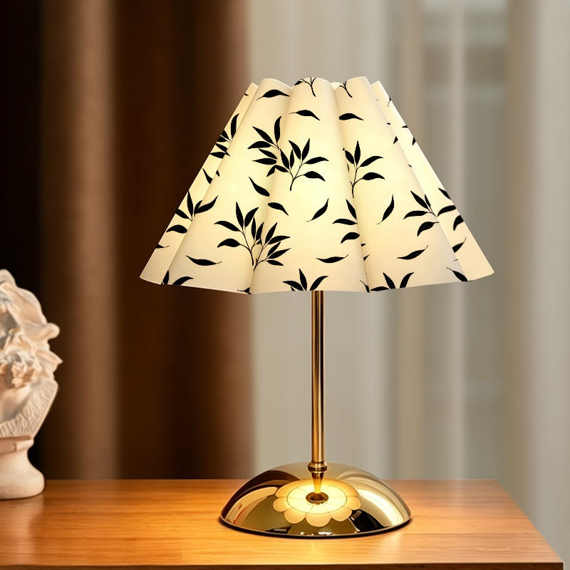 Lampe plissée au feuillage noir sur fond crème