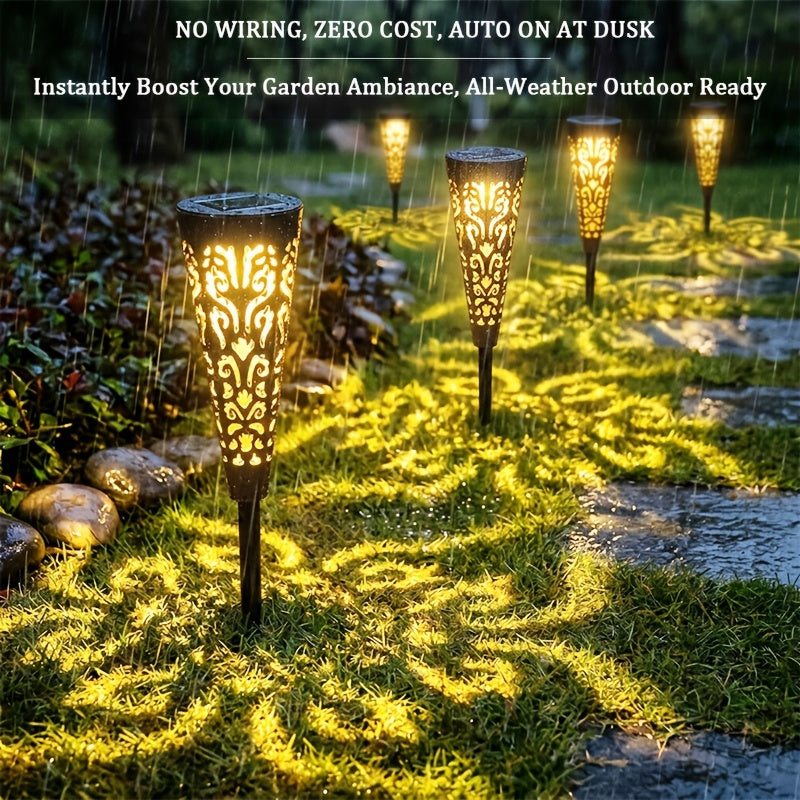 Lampe solaire torche ajourée noire, ombres florales sur l'allée
