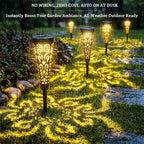 Lampe solaire torche ajourée noire, ombres florales sur l'allée