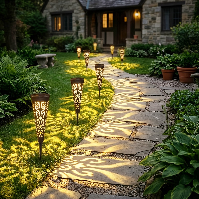 Lampe solaire torche ajourée noire, ombres florales sur l'allée
